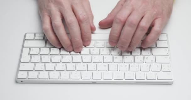 La persona está escribiendo en un teclado de computadora de color blanco, vista de cerca, luz suave, dispositivo bluetooth, tecnología inalámbrica — Vídeos de Stock