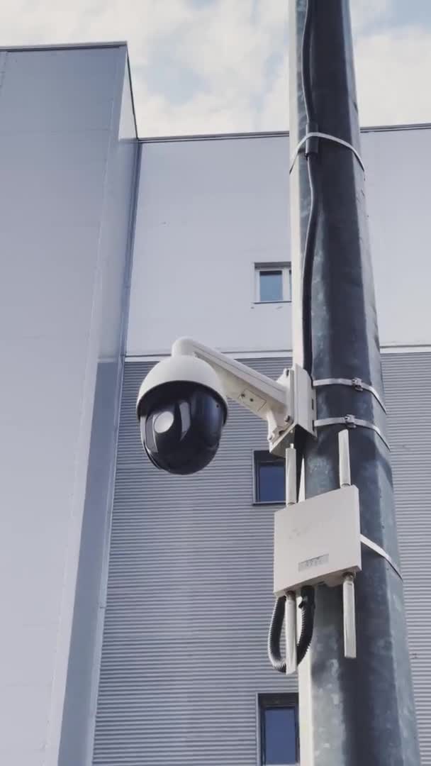 Russia, 13 квітня 2021: камера спостереження на металевій колонці, роутер бездротового зв'язку з антенами, будівля на задньому плані, вертикальні кадри — стокове відео