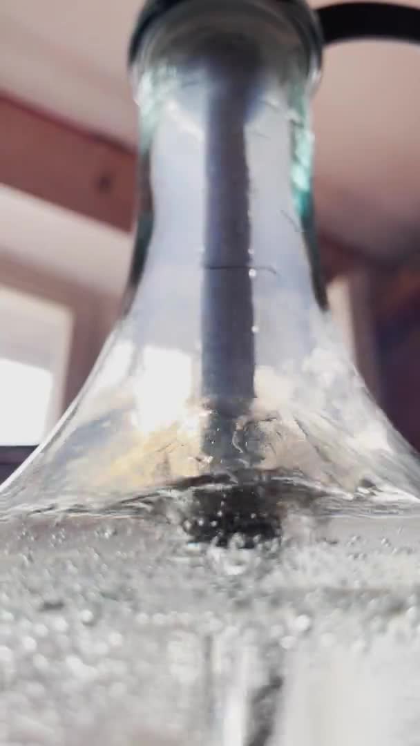 Su, nargile şişesi, matara duvarlarında hava şişeleri olan cam bir kaptaki tüpten çıkan baloncukların soyut bir videosu. — Stok video