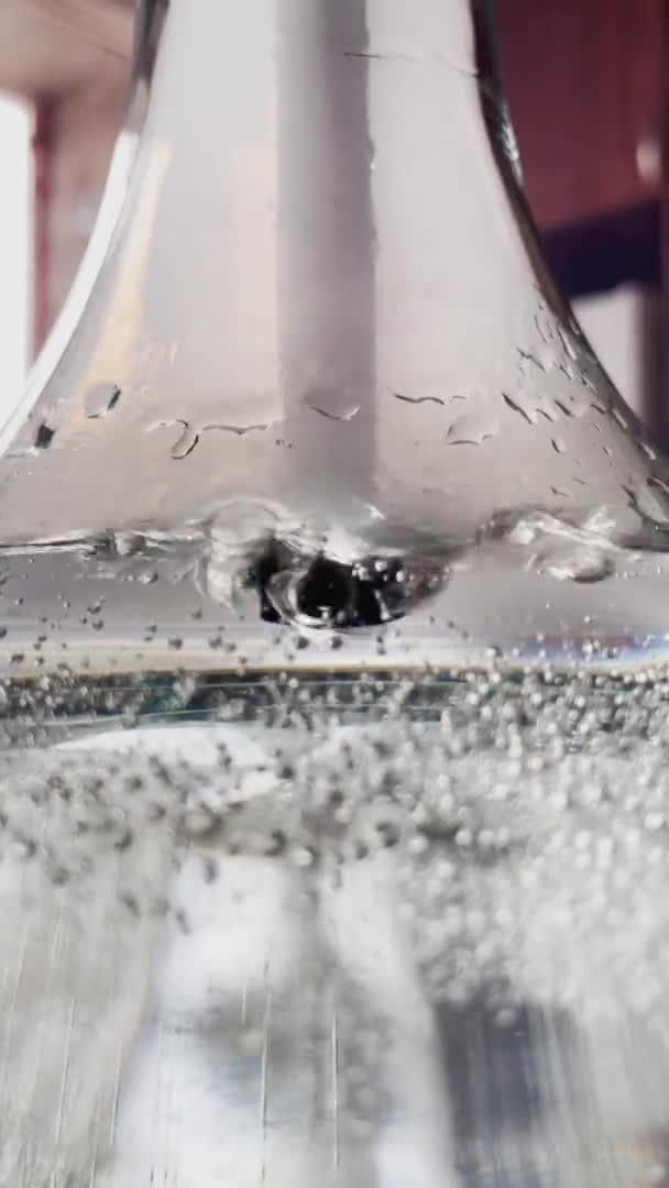 在一个装有水的玻璃器皿、一个钩子瓶、玻璃瓶壁上的空气瓶中的气泡的特写抽象视频 — 图库视频影像