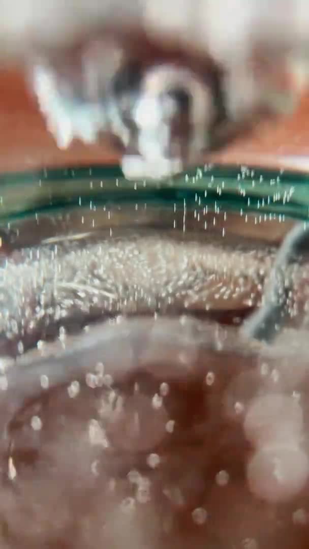 Lähikuva hidasliikkeinen abstrakti video lasiastiassa olevasta putkesta, jossa on vettä, vesipullo, pullollinen ilmaa pullojen seinillä, 24 fps — kuvapankkivideo