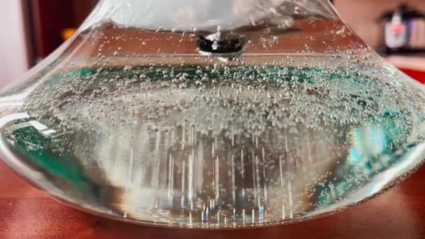 Primo piano video astratto al rallentatore di bolle da un tubo in un vaso di vetro con acqua, una fiaschetta di narghilè, fiale d'aria su pareti di fiaschetta, 24 fps — Video Stock