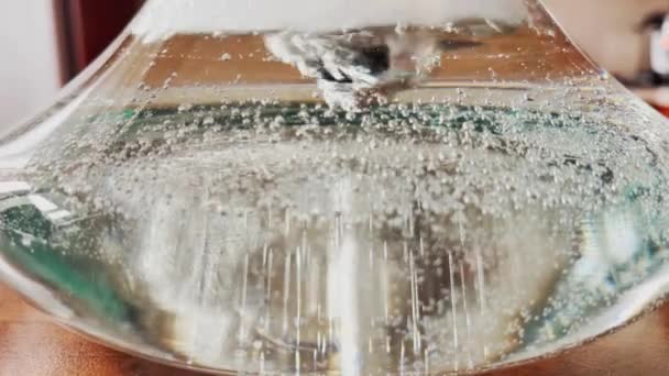 Gros plan vidéo abstraite de bulles provenant d'un tube dans un récipient en verre avec de l'eau, une fiole de narguilé, des flacons d'air sur les parois de la fiole — Video