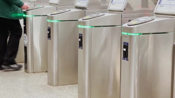 Passagiers zetten abonnementskaarten op contactloze betaalterminals bij een ingang van het metrostation, barrières, nfc systeemlezer — Stockvideo