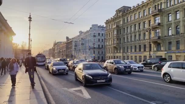 Rusya, St.Petersburg, 14 Nisan 2021: Nevsky Prospect 'in mimarisi araba trafiği, Kukla tiyatrosu, bir sürü ulaşım aracı, insanların ve arabaların uzun gölgeleri — Stok video