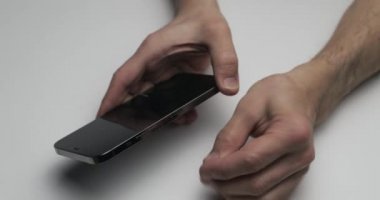 Rusya, St.Petersburg, 09 Nisan 2021: Beyaz masa arkaplanındaki iPhone 12 Pro Max paketini açma süreci, kişi telefondan bir iğne çıkarır ve yeni aygıtın yuvasına sim kart yerleştirir