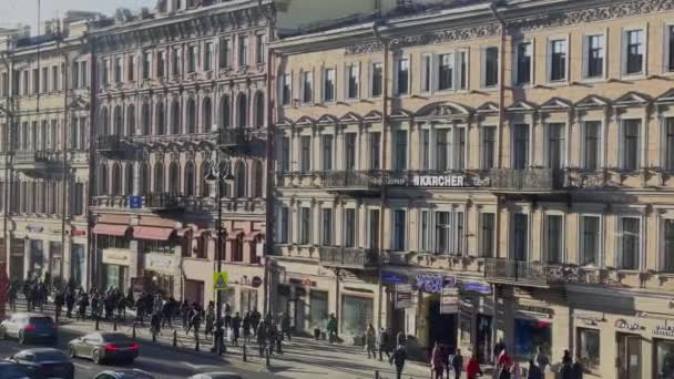 Rusland, Sint-Petersburg, 14 april 2021: De architectuur van Nevsky Avenue bij zonsondergang tijdens het autoverkeer, veel transportvoertuigen, lange schaduwen van mensen en auto 's — Stockvideo