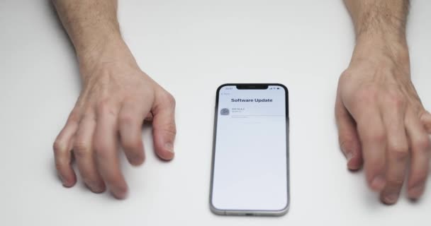 Russie, Saint-Pétersbourg, 09 avril 2021 : Un processus de déballage iPhone 12 Pro Max sur fond de table blanche, Doigts tapoter nerveusement sur une table en attente de la fin de la mise à jour du logiciel iOS — Video