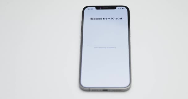 Russia, St.Petersburg, 09 April 2021: A process of unpacked iPhone 12 Pro Max on white table background, Recovery of data from an backup copy in cloudy storage iCloud — 비디오