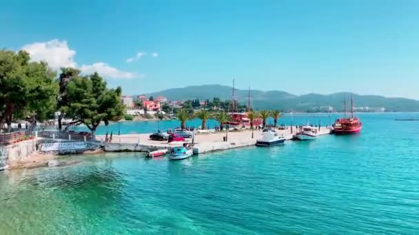 Grécia, Halkidiki, 13 de abril de 2019: As pessoas descem do ferry que chegou a uma das ilhas da Grécia no dia ensolarado, barcos de pesca, água azul, montanha em um fundo — Vídeo de Stock