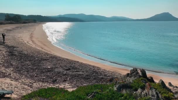 Malebná mořská krajina modré laguny s prázdnou veřejnou pláží při východu slunce, skalnaté pobřeží, hory na pozadí, bez turistů, azurová voda — Stock video