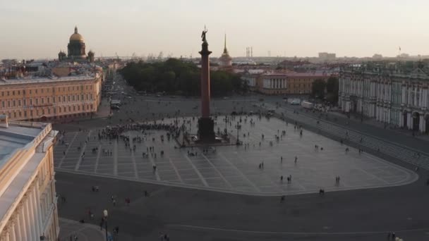 Flygbilder av Palace Square och Alexander Column vid solnedgången, en guldkupol av St Isaacs Cathedral, Vinterpalatset, Eremitaget, små människor går — Stockvideo