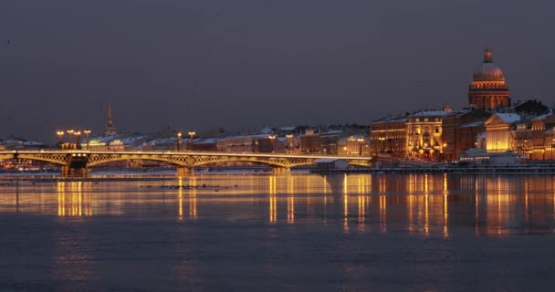 冬の夜の街のパノラマ映像サンクトペテルブルクの水の絵のような反射、背景にアイザック大聖堂、 Blagoveshensky橋、古い名前はシュミット中尉です — ストック動画
