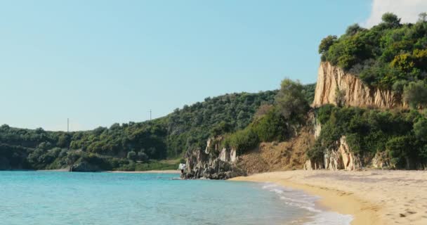 Ένα γραφικό θαλάσσιο τοπίο μιας γαλάζιας λιμνοθάλασσας με μια άδεια δημόσια παραλία την ανατολή του ηλίου, βραχώδη ακτή, βουνά σε φόντο, χωρίς τουρίστες, γαλανά νερά — Αρχείο Βίντεο