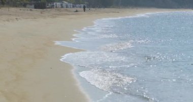 Gün doğumunda boş bir halk plajı olan mavi bir göl manzarası, turistsiz bir balıkçı, masmavi bir su, güneş yansımaları.