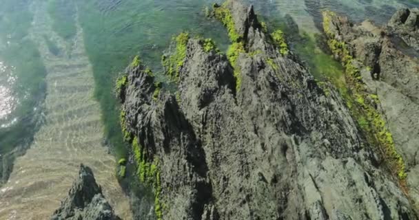 Неповторний морський пейзаж блакитної лагуни з гострими скелями на світанку, Скелясте узбережжя, гори на задньому плані, без туристів, блакитна вода. — стокове відео