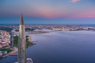Russia, St.Petersburg, 16 May 2021: Drone point of view of highest skyscraper in Europe Lakhta Center at pink sunset, Headquarters of the oil company Gazprom, stadium Gazprom Arena on background clipart