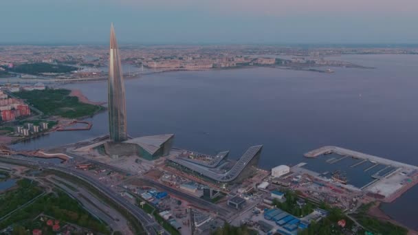 Rusya, St.Petersburg, 16 Mayıs 2021: Avrupa 'nın en yüksek gökdeleninden pembe gün batımında uçarak uzaklaşan insansız hava aracı, Gazprom, Gazprom Stadyumu' nun merkez binası. — Stok video