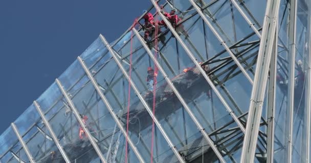 Russia, St. Petersburg, 14 August 2020: Skyscraper construction Lakhta for the oil company Gazprom, a facade glazing, builders lift big glasses on height by means of the high-rise construction crane — Stock Video