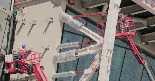 Ryssland, St Petersburg, 14 augusti 2020: Skyskrapa konstruktion Lakhta för oljebolaget Gazprom, en fasad glasering, byggare lyfta stora glasögon på höjden med hjälp av höghus byggkran — Stockvideo