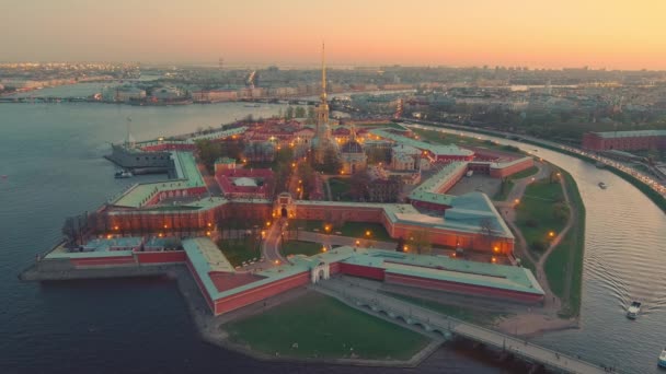 Drone flies up to the Peter and Paul cathedral and fortress at evening, the sights of St. Petersburg, the Neva river, Rostral columns, bridges, St. Isaac cathedral, the Admiralty — Stock Video