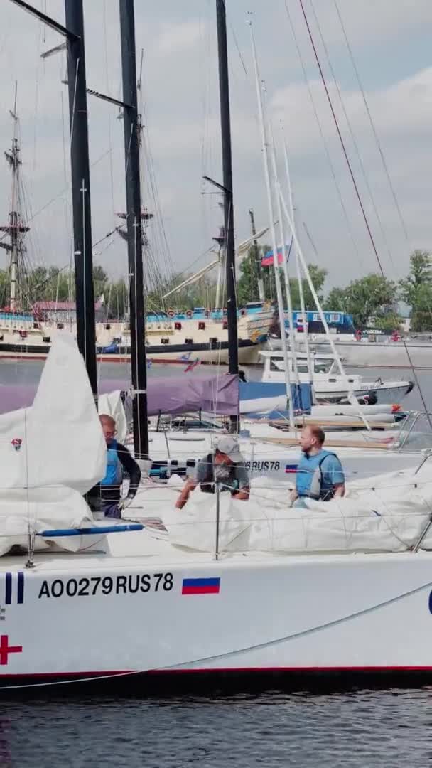 Russia, St.Petersburg, 18 June 2021: Yachtsmen and participants of a sailing regatta prepare boats in marina for an exit in the sea and the forthcoming sailing race — Stock Video