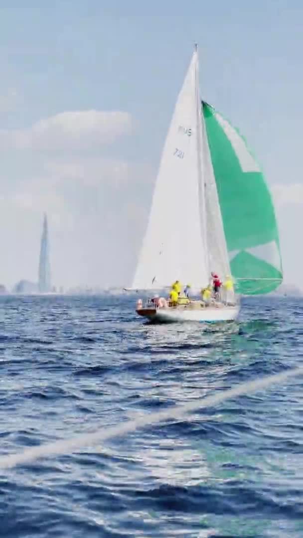 Rusland, Sint-Petersburg, 20 juni 2021: Regatta van zeilboten op zonnige dag, boten lopen verschillende tack, teams bereiden zich voor om gennaker, de heldere lucht, zeilen, reflectie van zeil op het water — Stockvideo