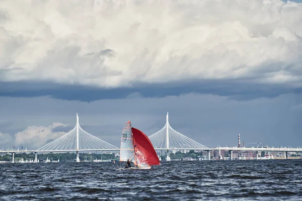 Russland, St. Petersburg, 23. Juli 2021: Wettbewerb der Segelboote am Horizont im Meer bei Sonnenuntergang, der erstaunliche Gewitterhimmel in verschiedenen Farben, Rennen, große Wellen, Segelregatta, Sonnenstrahlen, Teamarbeit — Stockfoto