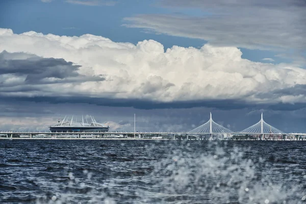 Rusland, Sint-Petersburg, 20 juni 2021: Nieuw stadion Gazprom Arena en kabelbrug aan de horizon, de Finse Golf, de bewolking, stormachtig weer, grote wolken — Stockfoto