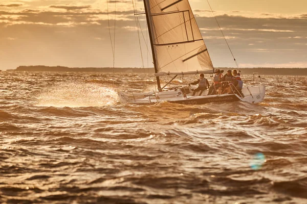 Rusland, St. Petersburg, 23 juli 2021: Wedstrijd van zeilboten aan de horizon in zee bij zonsondergang, de geweldige storm hemel van verschillende kleuren, race, grote golven, zeilregatta, zonnestralen, teamwork — Stockfoto