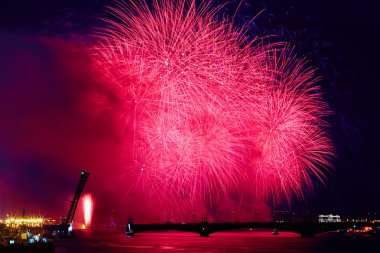 Russia, St. Petersburg, 20.6.2015: Fireworks on the Neva River on a holiday SCARLET SAILS diluted Troitsky Bridge, Rastralnye colony on the Spit of Vasilyevsky Island, a lot of people on the Palace Embankment, water flashes red, white night, holiday clipart
