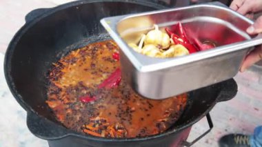 Özbek milli yemek pilavı nın üzerine büyük bir dökme demir kazanı, dilimlenmiş kırmızı havuç, böğürtlen, sarımsak ve kırmızı biber, pirinç, kuzu, koyun yağı, yağ kuyruğu, susam yağı eklenir