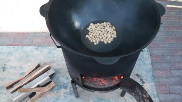 Usbekisches Nationalgericht Pilaf in einem großen gusseisernen Kessel auf dem Feuer, der Kochprozess, gebratene Fettschwanzstücke, Grundlage für Lebensmittel Reis, Lamm, Karotten, Hammelfett, Sesamöl, Zwiebeln, Knoblauch, Kreuzkümmel, Pfeffer, Zirvak, Fergana — Stockvideo