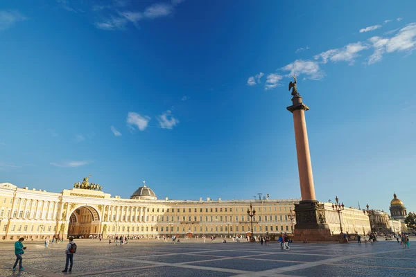 Oroszország, Szentpétervár, 14.08.2015: idő telik el a palota tér és az Alexander oszlop, naplemente, rózsaszín felhők, egy csomó ember a főtér, nedves macskakövön — Stock Fotó