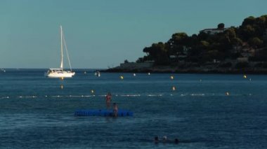 Fransa, Menton, 2015.08.27: plaj plastik duba üzerinde pek çok çocuk banyo Menton, Roquebrune Cap Martin, Provence Alpes Cote dazur, masmavi su, yatlar arka planda, yelkenli tekne