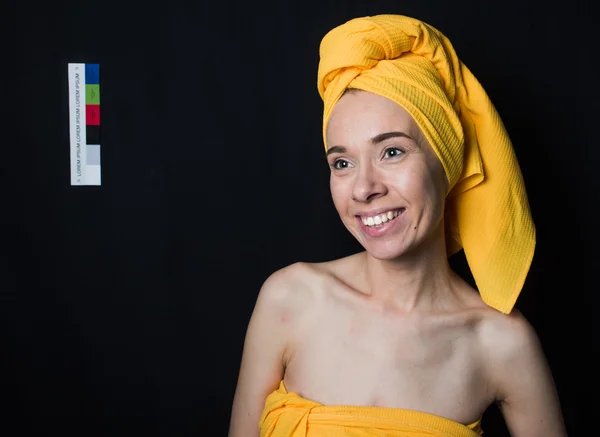 Uma menina sorridente em uma toalha amarela Fotografia De Stock