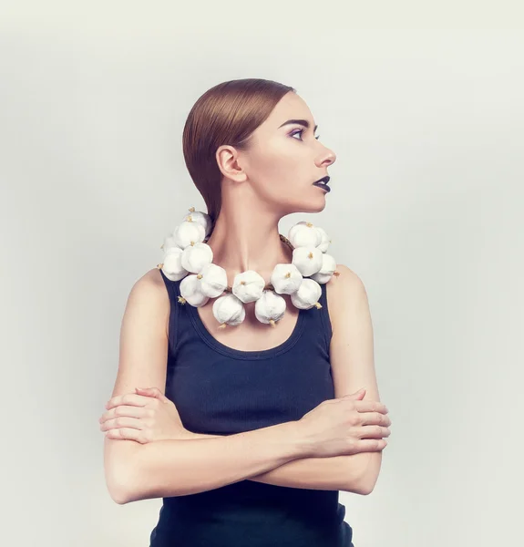 Woman with a collar of white garlic — Stock Photo, Image