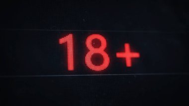 Under 18 rating sign. 18+ red pixel text on old dusty screen.