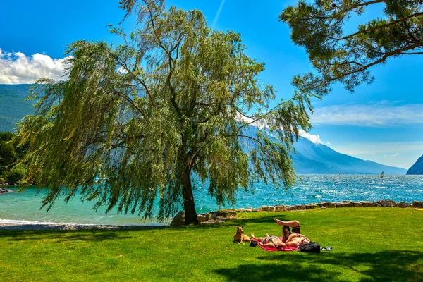 リヴァ ガルダ ガルダ イタリア 6月2020 ガルダ湖で日焼けするビーチに入浴し 座っている人々 夏の時間に山に囲まれた美しいガルダ湖 — ストック写真
