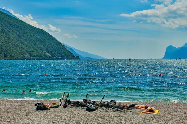 リヴァ ガルダ ガルダ イタリア 6月2020 ガルダ湖で日焼けするビーチに入浴し 座っている人々 夏の時間に山に囲まれた美しいガルダ湖 — ストック写真