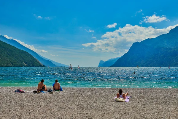 リヴァ ガルダ ガルダ イタリア 6月2020 ガルダ湖で日焼けするビーチに入浴し 座っている人々 夏の時間に山に囲まれた美しいガルダ湖 — ストック写真