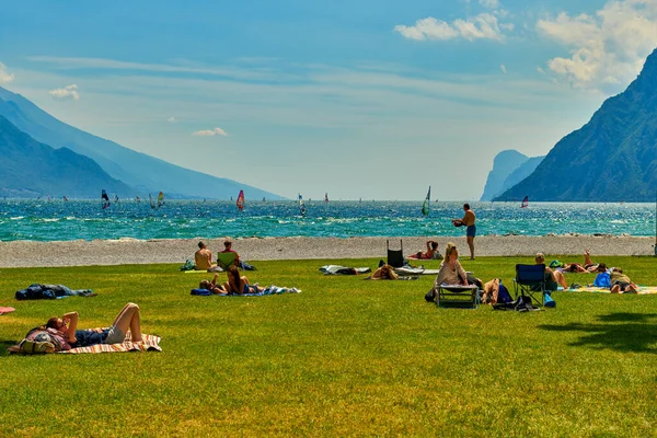 リヴァ ガルダ ガルダ イタリア 6月2020 ガルダ湖で日焼けするビーチに入浴し 座っている人々 夏の時間に山に囲まれた美しいガルダ湖 — ストック写真