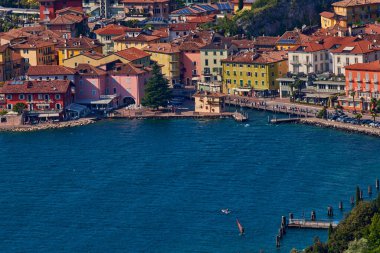Nago-Torbole yakınlarındaki Busatte-Tempesta patikasından Garda Gölü 'ne panoramik manzara, Torbole kasabası, yaz aylarında dağlarla çevrili, İtalya