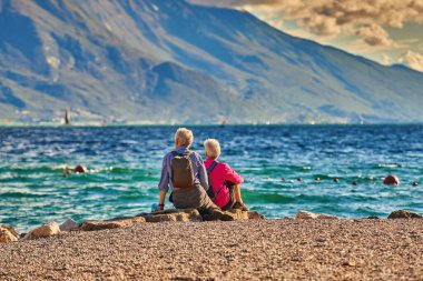 Aile, İtalya 'nın dağlarıyla çevrili Garda Gölü manzarasına hayran.