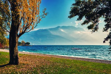 Dağlarla çevrili güzel Garda Gölü manzarası Riva del Garda 'daki Garda Gölü' nde gün batımı manzarası güzel günbatımı renkleriyle, İtalya