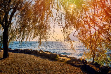 Dağlarla çevrili güzel Garda Gölü manzarası Riva del Garda 'daki Garda Gölü' nde gün batımı manzarası güzel günbatımı renkleriyle, İtalya