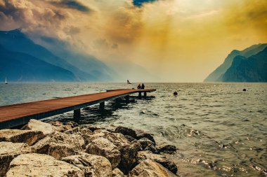 Dağlarla çevrili güzel Garda Gölü manzarası Riva del Garda 'daki Garda Gölü' nde gün batımı manzarası güzel günbatımı renkleriyle, İtalya