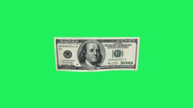Gerçekçi dolar banknotu yeşil arka planda süzülür.