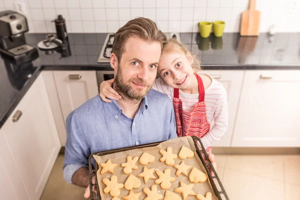 Pai e filha segurando bandeja com biscoitos caseiros — Fotografia de Stock