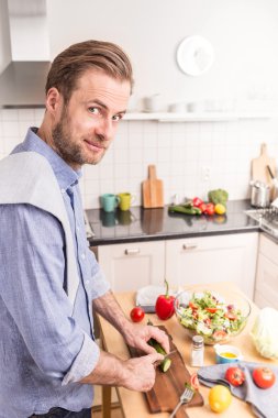 Salata yapmak için sebze doğrama mutlu gülümseyen adam